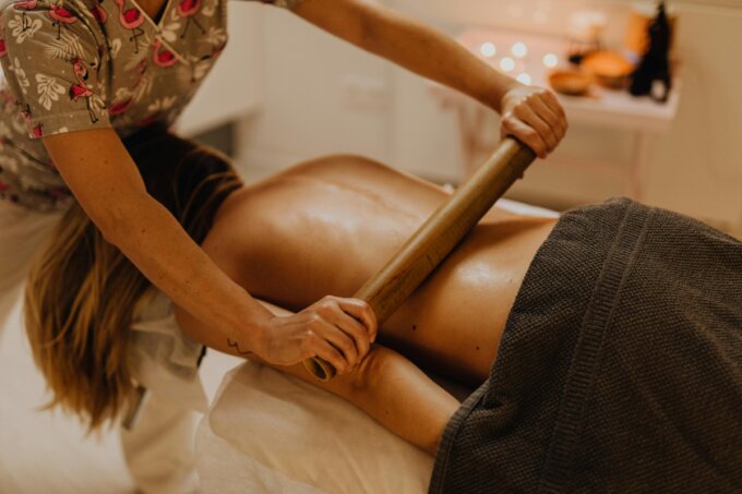 Therapist using warm bamboo tools during a relaxing back massage